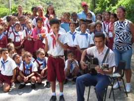 Des enfants costumés à Cuba écoutent un guitariste