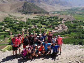 Des randonneurs au sommet d'une montagne avec vue sur un village