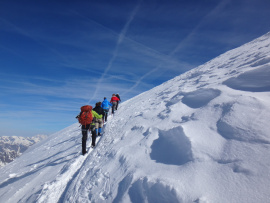 Des randonneurs grimpent sur une montagne enneigée