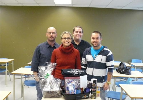 Yanick Descheneaux, enseignant, Guillaume Gaudet, étudiant de 2e année et Jean-Michel Lefebvre, étudiant de 3e année entourent la gagnante du panier-cadeau Isabelle Letendre.