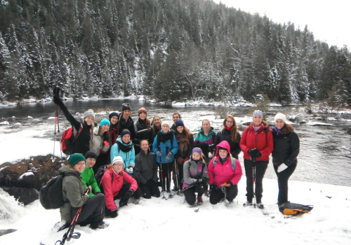 Les membres du Club de plein air La Cordelle sur le bord d'un cours d'eau en hiver