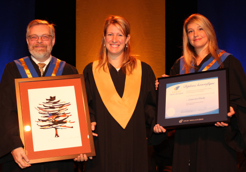 Le directeur général du Cégep de Trois-Rivières, Raymond-Robert Tremblay et la présidente du conseil d'administration, Karine Provencher, remettent un diplôme honorifique ainsi qu’une toile de l’artiste et enseignante Élise Proulx à Mme Geneviève Hardy.