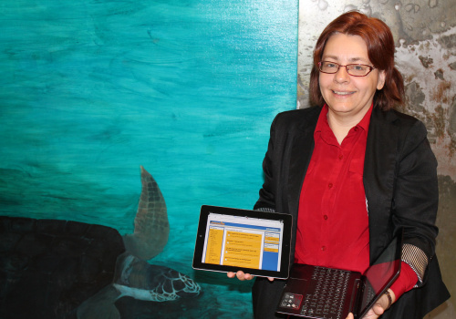 Chantal Desrosiers tenant une tablette et un portable