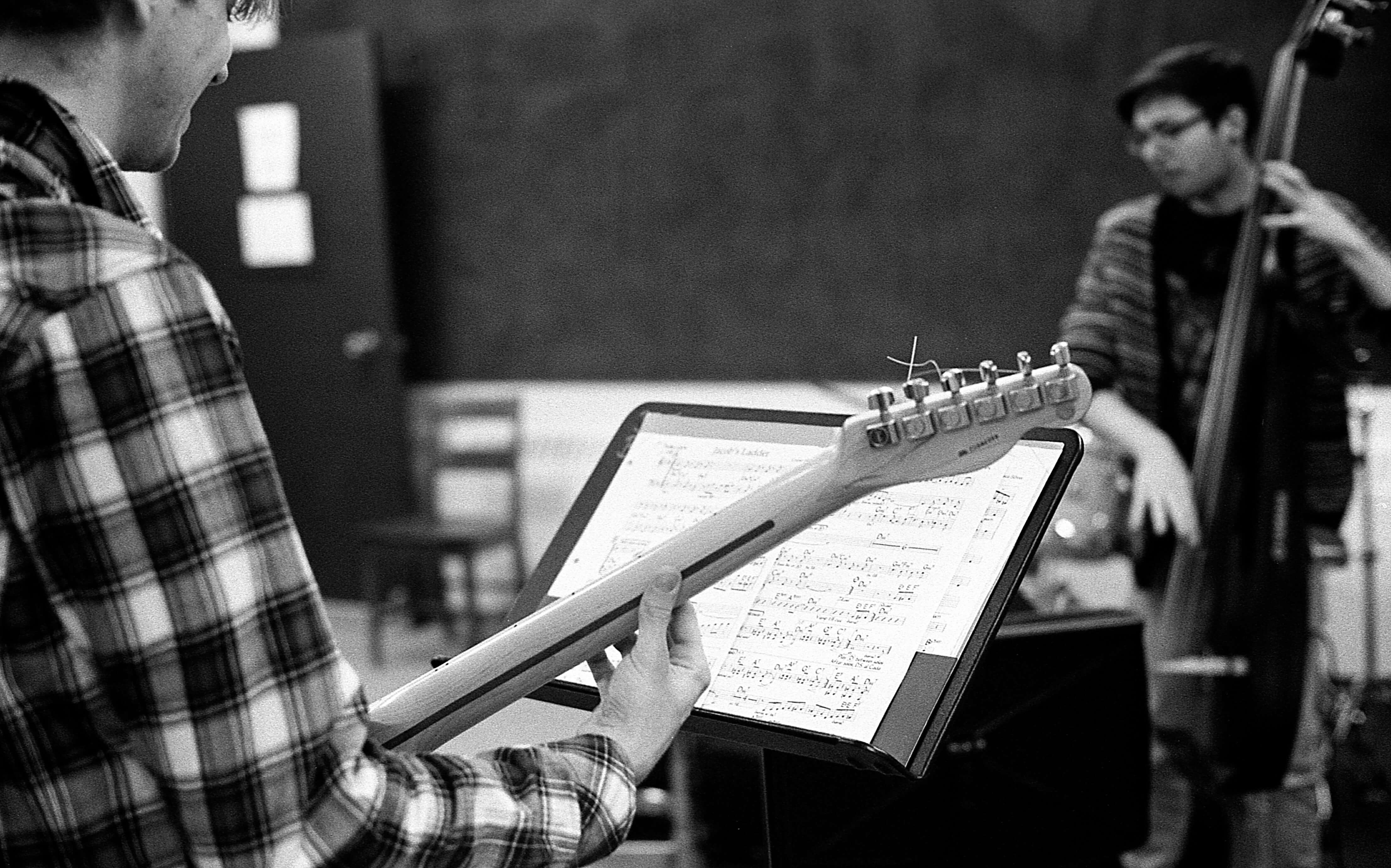 Un violoncelliste et un guitariste regarde sa partition de musique