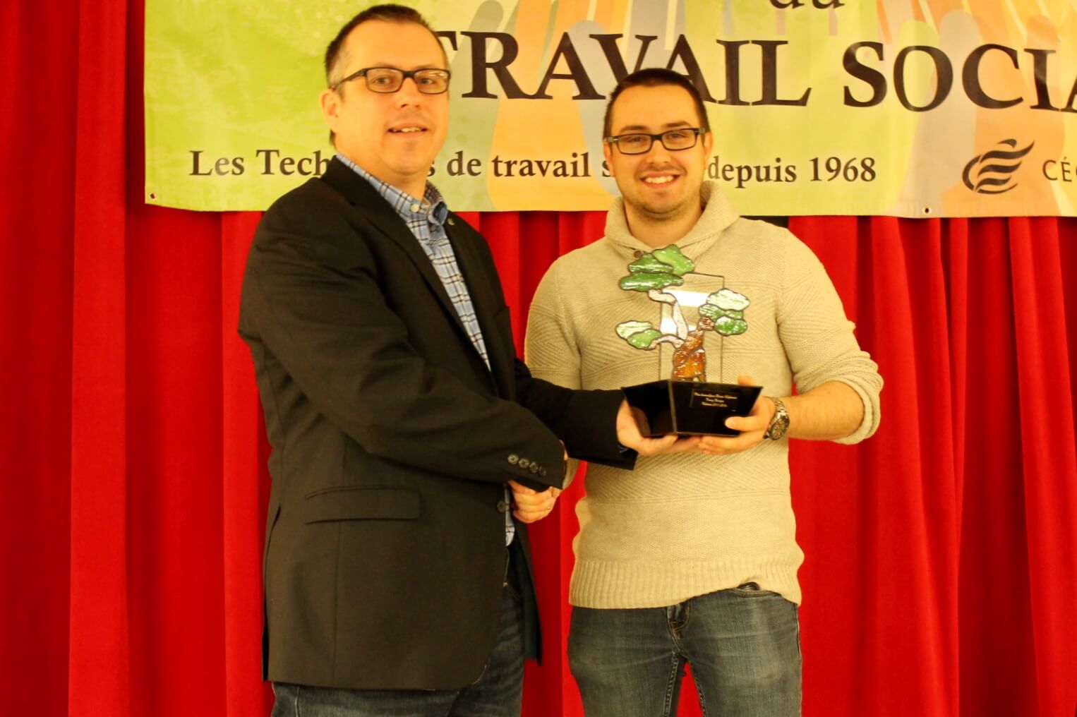 Le directeur des études, Denis Rousseau, remet le trophée à Tommy Derasp.