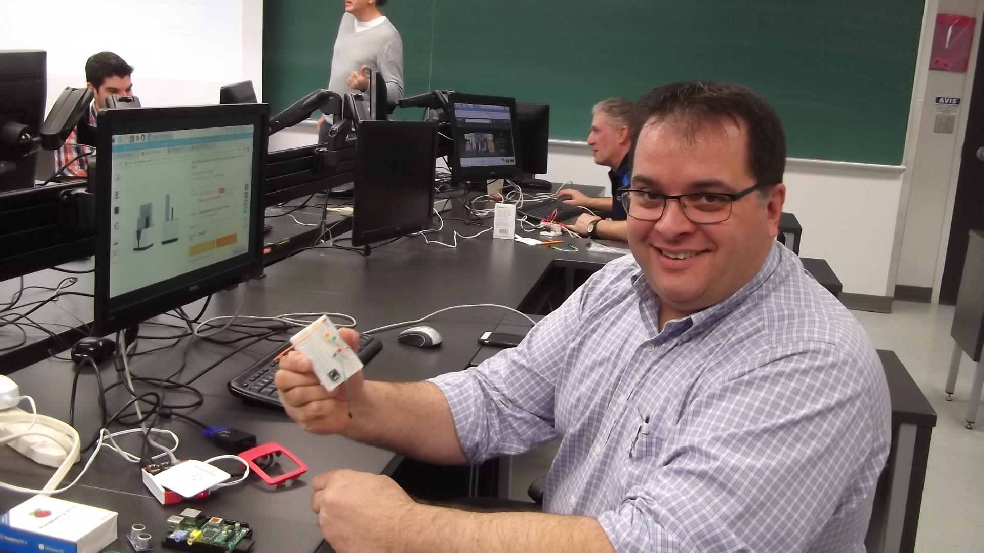 Un homme devant son écran d'ordinateur montre un connecteur