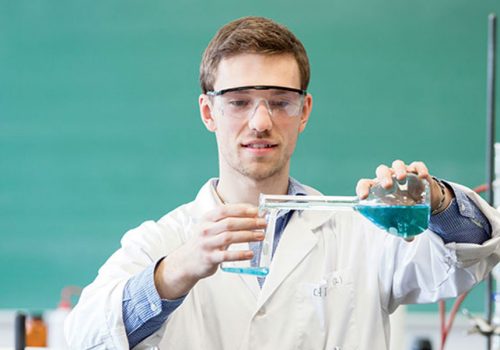 Un étudiant en Sciences de la nature verse du liquide dans une éprouvette
