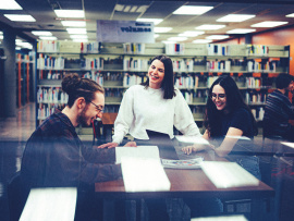 Trois personnes assises devant des livres