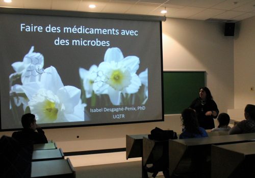 Sur un écran géant, la présentation Faire des médicaments avec des microbes par Isabel Desgagné-Pénix