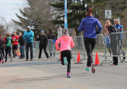 Une maman et sa fille courent avec les encouragements de la foule