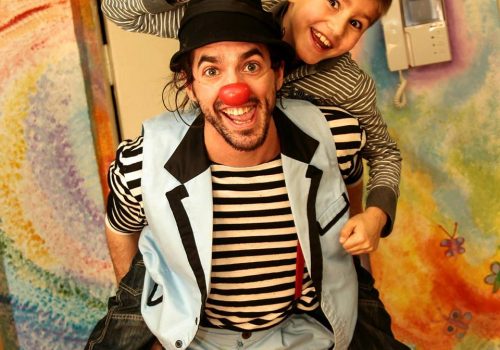 Guillaume Vermette, clown humanitaire porte une enfant sur son dos