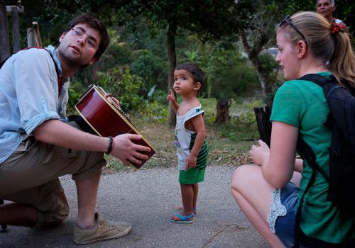 Une étudiante en stage à Cuba avec un enfant et un guitariste