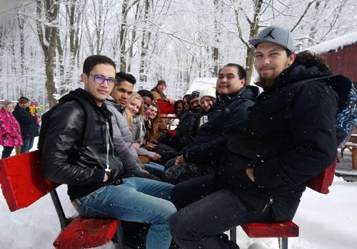 Des étudiants dans une carriole à la cabane à sucre