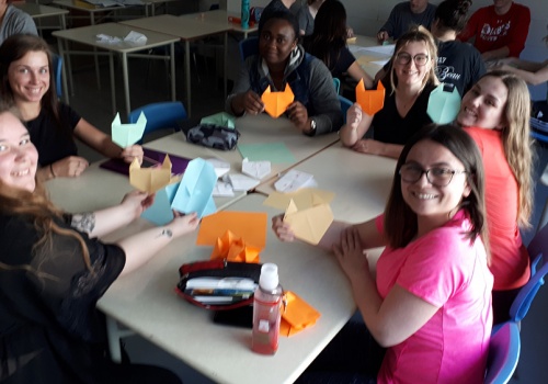 Des étudiantes assises à une table font de l'origami