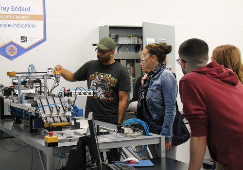 Des c.o. en visite au cégep regardent une démonstration d'un étudiant en Électronique industrielle