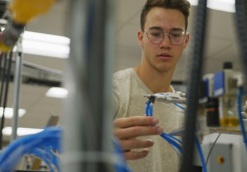 Un étudiant en Génie électrique devant des équipements