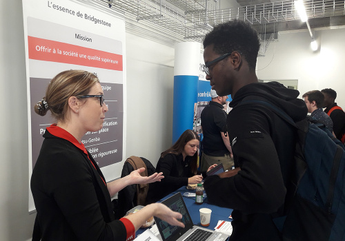 Un étudiant discute avec un employeur au Salon de l'emploi 2019