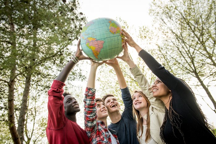 Cinq jeunes tiennent ensemble un globe terrestre