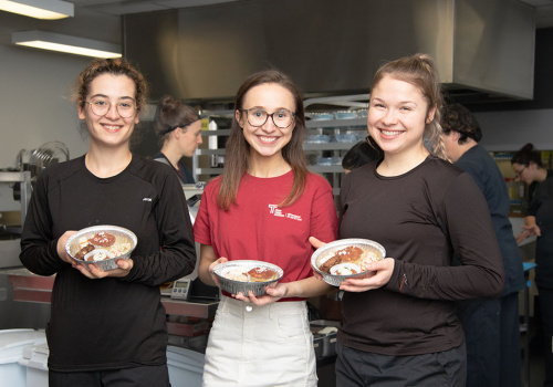 Trois étudiantes tiennent des desserts