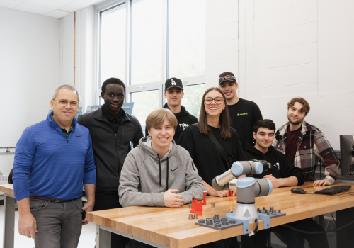 François Cloutier, enseignant en Génie mécanique au Cégep de Trois-Rivières, accompagné des étudiant·es du programme qui participent à la compétition Robotfly plus