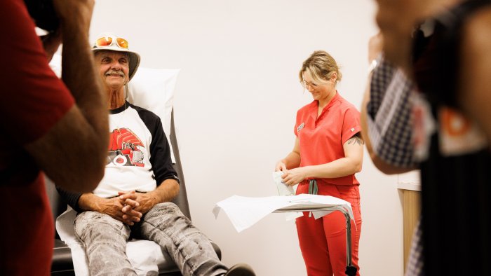 Infirmière avec un patient assis sur une civière