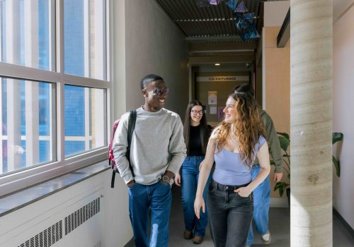 3 étudiants qui marchent dans un couloir